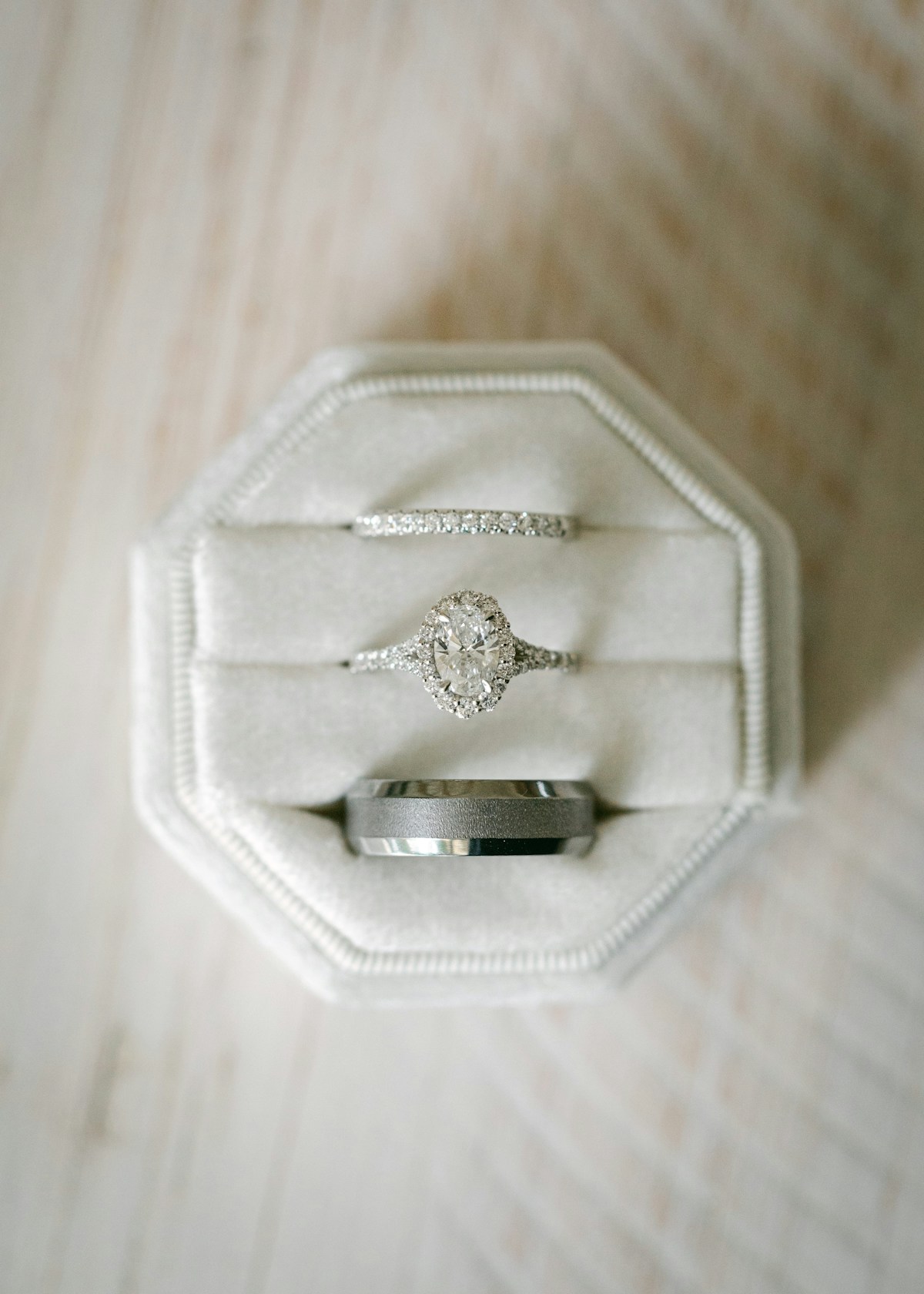 A bridal ring set — halo engagement ring and two bands — in an elegant velvet box
