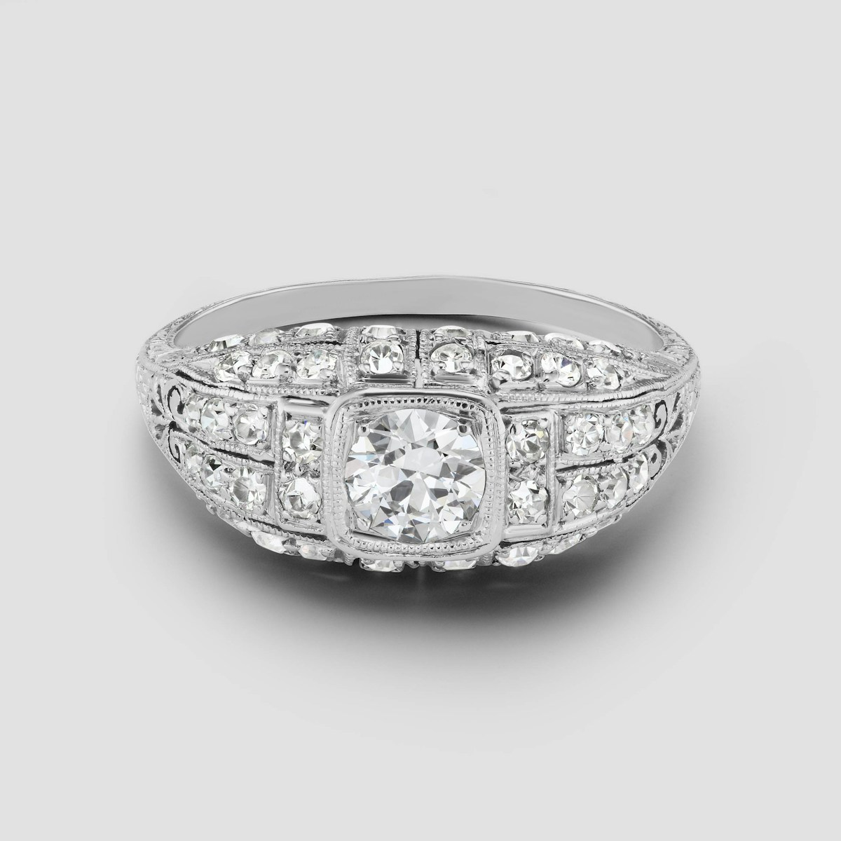 A platinum art deco engagement ring with milgrain detail and pavé diamonds
